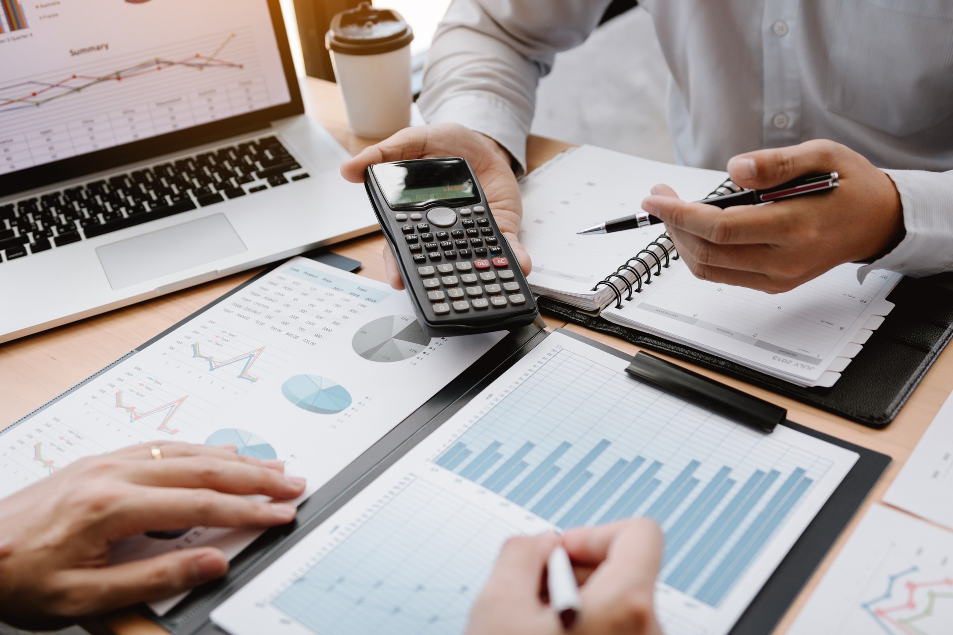 Two businessmen discussion analysis sharing calculations about the company budget and financial planning together on desk at the office room.